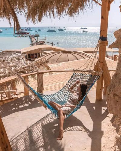 a woman laying in a hammock on a beach at Hurghada in Hurghada
