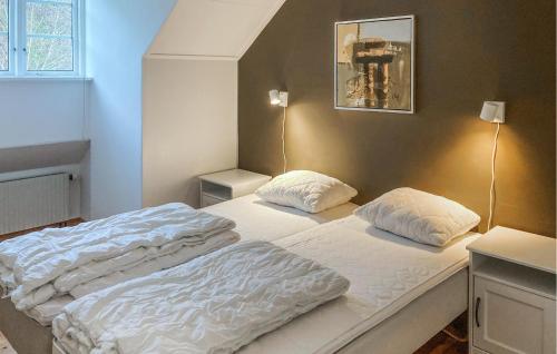 a bed with two pillows on it in a room at Amazing Home In Trans With Sauna in Tranås