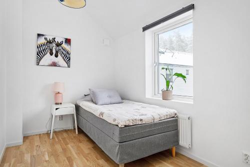 a bedroom with a bed and a window at Luxurious newly built villa with patio and private parking in Sigtuna