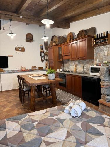 a large kitchen with a wooden table and a tableasteryasteryasteryasteryasteryastery at B&B La Baita "monolocale ad uso esclusivo" in Fonni