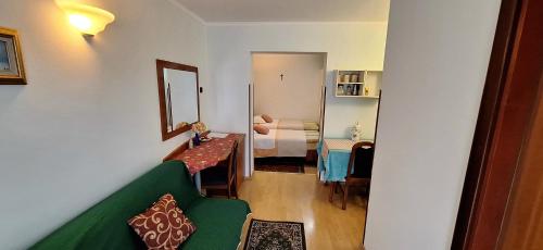 a living room with a green couch and a bedroom at Apartments and Rooms Laura in Pazin