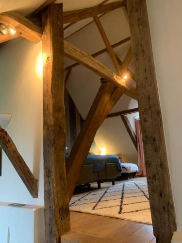 a living room with wooden beams and a blue couch at Hamiora wellness B&B in Deinze