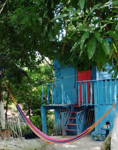 a colorful tree house with a rope around it at Hospedaje y jardin botanico chiltun maya in El Remate