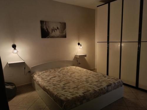 1 dormitorio con 1 cama con 2 luces en la pared en Casa vacanze Giosuè en Noto Marina