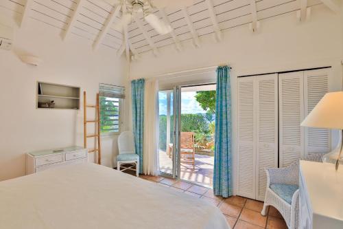 a bedroom with a bed and a door to a patio at Luxury Vacation Villa 2 in Pointe Milou