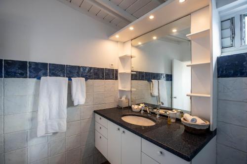 baño con lavabo y espejo grande en Luxury Vacation Villa 2, en Pointe Milou