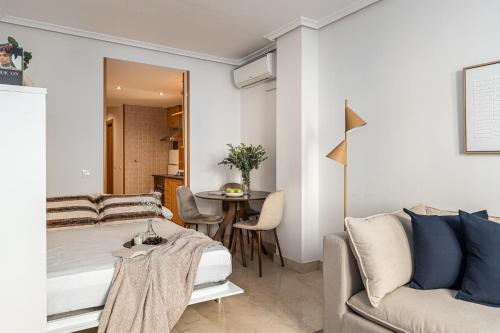 uma sala de estar com uma cama e uma mesa em BNBHolder Loving Gran Via Apartment III em Madri