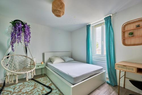 a bedroom with a bed and a chair and a window at Cottage Côté Mer - A 1km de la plage in Courseulles-sur-Mer