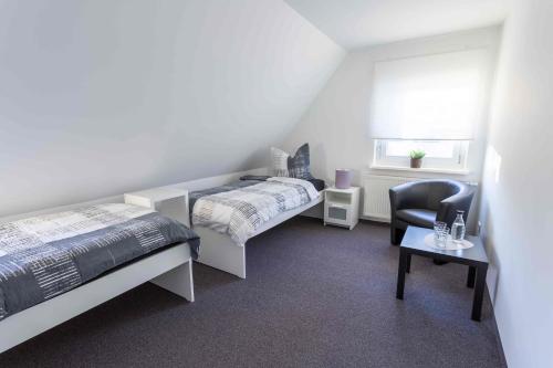 ニュルンベルクにあるClaudias Apartment - 20 Minuten bis Messe Nürnbergのベッドルーム1室(ベッド2台、椅子、窓付)
