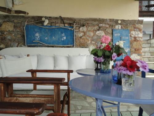 a living room with a table with flowers on it at Aperanto Galazio in Skopelos Town