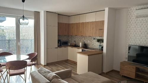 uma cozinha e sala de estar com um sofá e uma mesa em Apartament 33 Park City em Ostrów Wielkopolski