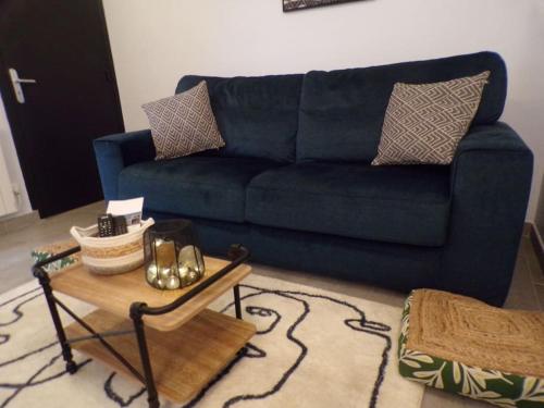 uma sala de estar com um sofá azul e uma mesa de centro em Logement proche centre et plage em Le Portel