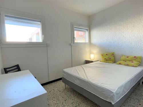 een slaapkamer met een bed met gele kussens en een raam bij Appartement Port-la-Nouvelle, 2 pièces, 4 personnes - FR-1-229C-26 in Port-la-Nouvelle