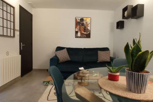 uma sala de estar com uma mesa de vidro e um sofá em Logement proche centre et plage em Le Portel