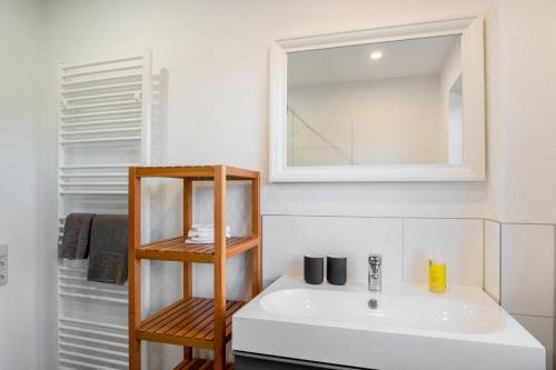 La salle de bains est pourvue d'un lavabo blanc et d'un miroir. dans l'établissement Ferienhof Gröne, à Eutin