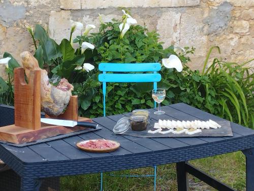 una mesa azul con un plato de comida y una copa de vino en Cheval nomad' en La Goulaudie