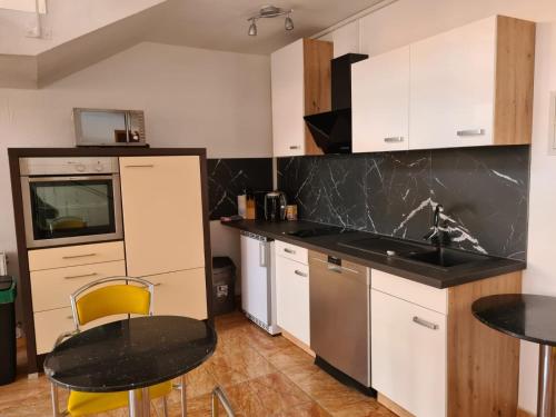 uma cozinha com armários brancos e um balcão preto em Ferienhaus em Barleben