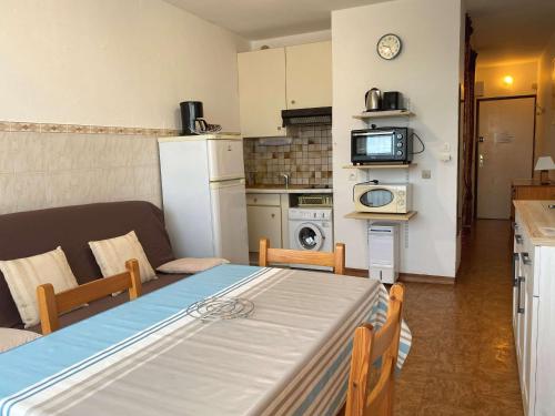 un salon avec une table et une cuisine dans l'établissement Charmant T1 lumineux avec cuisine équipée, coin nuit séparé et wifi - Balaruc-les-Bains - FR-1-553-48, à Balaruc-les-Bains