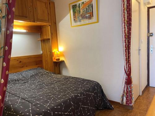 - une chambre avec un lit et une couette noire dans l'établissement Charmant T1 lumineux avec cuisine équipée, coin nuit séparé et wifi - Balaruc-les-Bains - FR-1-553-48, à Balaruc-les-Bains