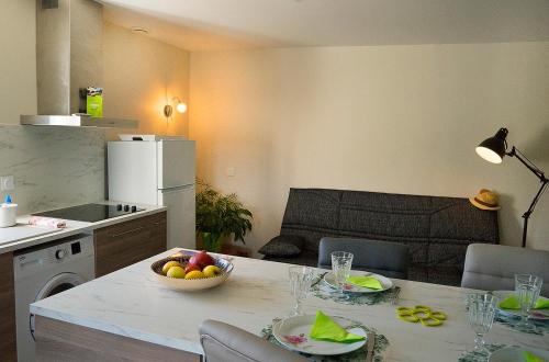 una cocina con una mesa con un bol de fruta. en A l'appartement chez REVIGORA, en Vienne