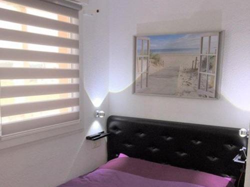 - une chambre avec un lit et une fenêtre avec une photo dans l'établissement Appartement pour 4 pers avec piscine et terrasse, parking privé, animaux acceptés - FR-1-379-152, à Vieux-Boucau-les-Bains
