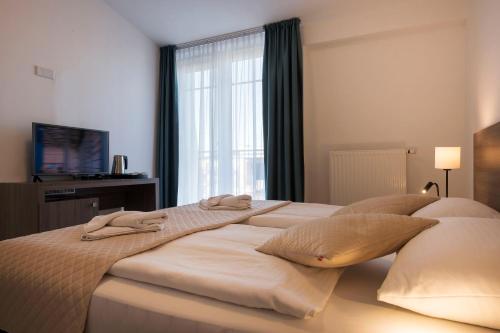 a bedroom with two beds with pillows and a window at MariSol in Świnoujście
