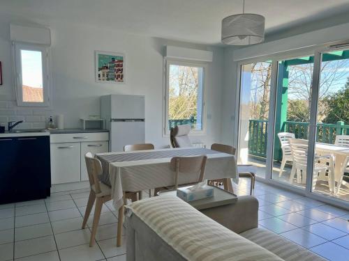 une cuisine et un salon avec une table et des chaises dans l'établissement Confort à Cambo : T2 pour 2 pers., balcon-terrasse, cuisine équipée, parking, accès internet - FR-1-495-133, à Cambo-les-Bains