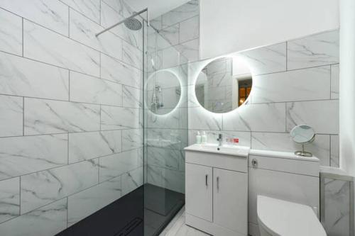 柯克麥科爾的住宿－Strathardle Lodge，白色的浴室设有水槽和淋浴。