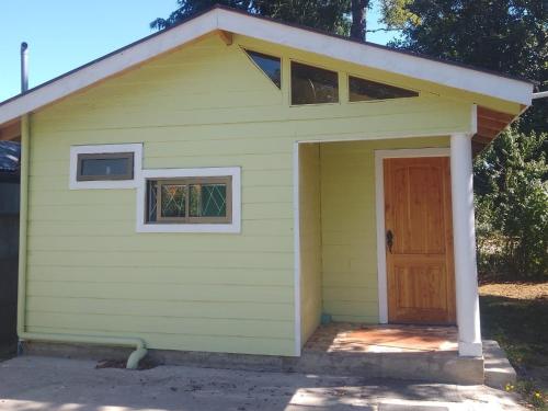 a yellow garage with a door and a window at cabaña valdivia 2 in Valdivia