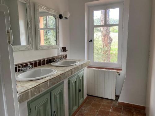 a bathroom with two sinks and two windows at Mas provençal dans un vignoble in La Motte