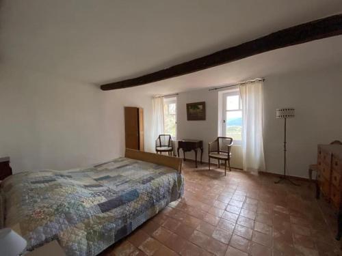 une chambre avec un lit, une table et des chaises dans l'établissement Mas provençal dans un vignoble, à La Motte
