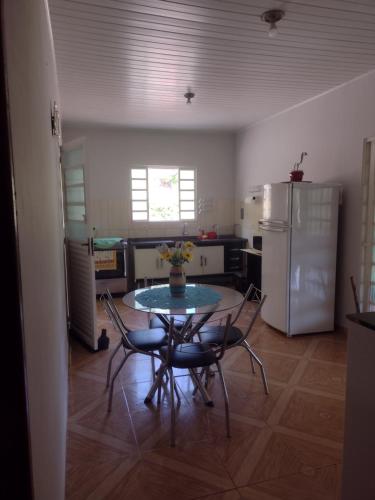 eine Küche mit einem Tisch und Stühlen sowie einem Kühlschrank in der Unterkunft Recanto da Alegria in Córrego do Bom Jesus