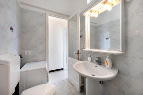 ein weißes Bad mit einem WC und einem Waschbecken in der Unterkunft Casa Francesca in Levanto