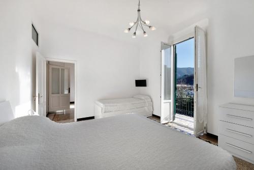 ein weißes Schlafzimmer mit einem Bett und einem Fenster in der Unterkunft Casa Francesca in Levanto