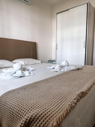 a bed with white sheets and towels on it at Quality - Boas Vistas in Canoa Quebrada