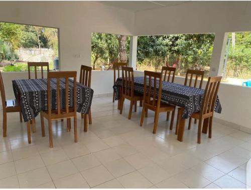 een eetkamer met een tafel en stoelen en een tafel en een stoeltje bij CAMPEMENT DIAMORAL DIAKENE OULOFF in Diakène Ouolof