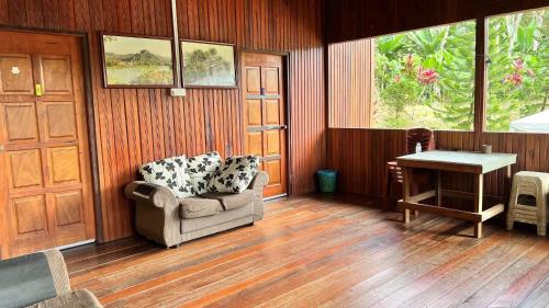 uma sala de estar com uma cadeira e uma mesa em Country house Pulai Holiday Village em Gua Musang