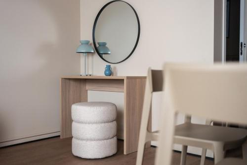 a mirror sitting on top of a table with a stool at Sky Hotel Apartments, Stockholm in Stockholm