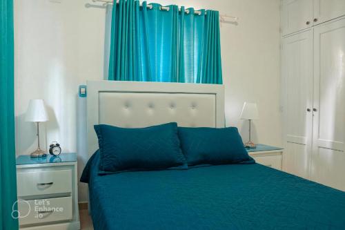 a bedroom with a blue bed and blue curtains at Ria Aparta Hotel in San Felipe de Puerto Plata