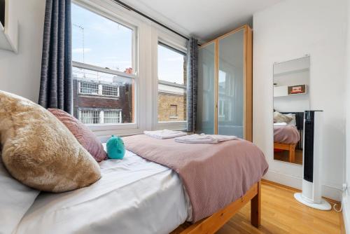 a bedroom with a bed with a large window at Modern Living in the Heart of Covent Garden! 6BC in London