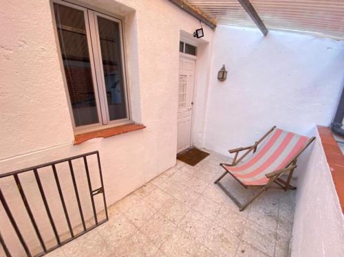 una silla sentada en un porche junto a una ventana en Cardeñosa habitaciones, en Madrid