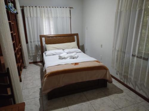 a bedroom with a bed with two towels on it at Pousada Bonamigos in Santa Teresa