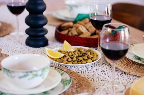 a table with glasses of wine and a basket of food at LILY'S VILLA LEMONIA in Platanes
