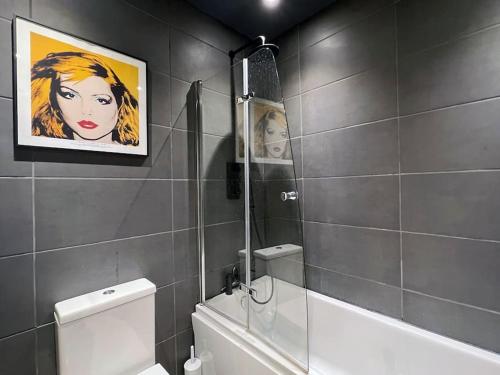 a bathroom with a painting of a woman on the wall at Poets Rest, free parking, EV socket fees apply walk to beach in Brighton & Hove