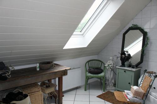 a attic room with a mirror and a chair at Ruhiges, helles Altbauzimmer im Stadtzentrum in Schwelm