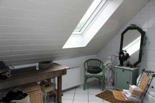 a attic room with a mirror and a chair at Ruhiges, helles Altbauzimmer im Stadtzentrum Privatunterkunft in Schwelm