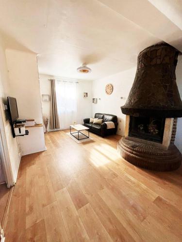 a living room with a fireplace and a couch at Merveilleux appartement style nature proche centre ville in Collioure