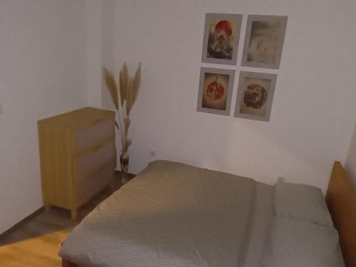 ein Schlafzimmer mit einem Bett und einer Kommode und Bildern an der Wand in der Unterkunft Domeček in Trutnov