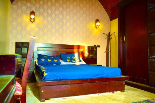 a bedroom with a bed with blue sheets and blue pillows at Kony Nubian Guest House in Abu Simbel