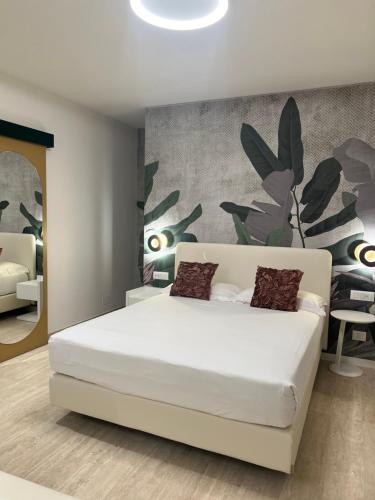 a bedroom with a white bed and a wall with plants at Astoria Suite Hotel in Rimini